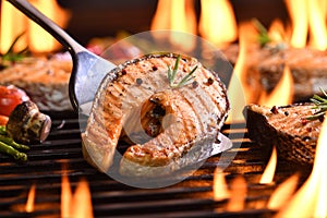 Grilled salmon fish on the flaming grill
