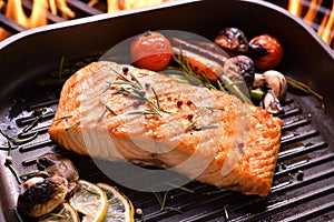Grilled salmon fish with various vegetables on pan