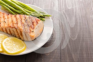 Grilled salmon and lemon, asparagus, on the wooden table