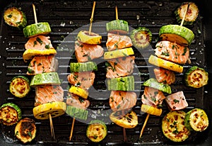 Grilled salmon skewers with zucchini and herb marinade in a grill pan