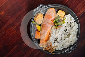 Grilled salmon steak with seasoned rice and vegetables, Japanese style, top view