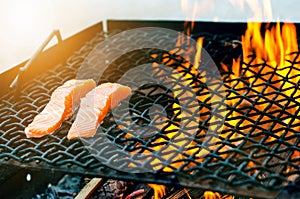 Grilled salmon steaks on a grill. Fire flame grill. Restaurant and garden kitchen. Garden party. Healthy dish.