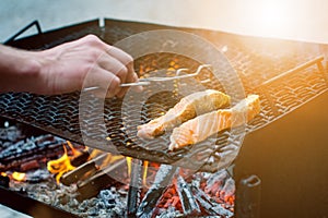 Grilled salmon steaks on a grill. Fire flame grill. Restaurant and garden kitchen. Garden party. Healthy dish.