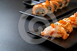 grilled salmon sushi on black plate