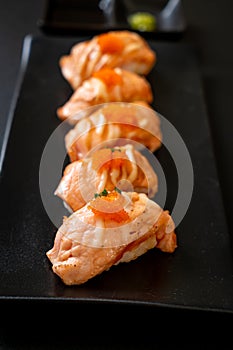 grilled salmon sushi on black plate