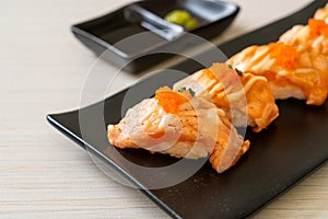 grilled salmon sushi on black plate