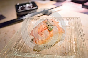 Grilled Salmon Sushi with lime slice in transparent dish