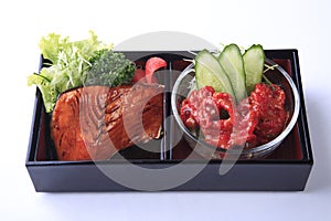 Grilled salmon teriyaki with spicy tentacles in bento isolated o