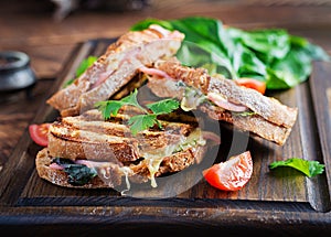 Grilled sandwich panini with ham, tomato, cheese and spinach