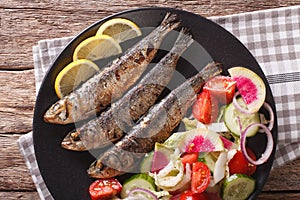 Grilled sardines with a salad of cucumber, radish, tomato, onion