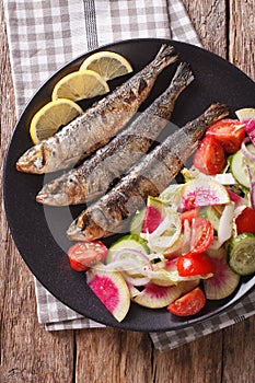 Grilled sardines with a salad of cucumber, radish, tomato, onion