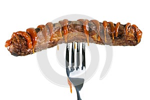 Grilled sausage decorated with ketchup pierced on a fork, isolated on white