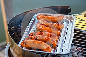 Grilled sausage on the flaming grill