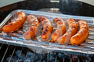 Grilled sausage on the flaming grill