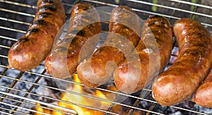 Grilled sausage on the flaming grill