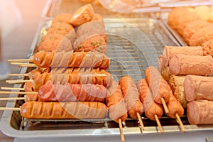 Grilled sausage on the flaming grill prepared for sale at local