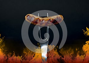 Grilled Sausage on Fork with Flames photo