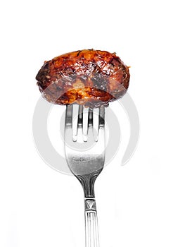 Grilled sausage is pricked on a fork.