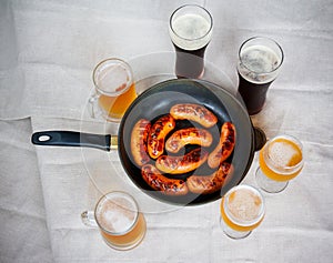 Grilled sausages and beer glasses on table. Top view