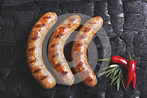 Grilled sausages on a black background of charcoal. Barbecue grill