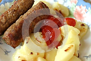 Grilled sausages and coocked potatoes photo