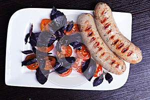 Grilled sausages with easy side dish of cherry tomatoes, basil