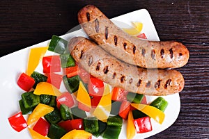 Grilled sausages with easy side dish of peppers, yellow, green, red