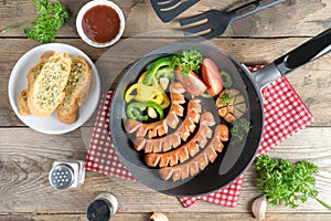 Grilled sausages on a frying pan.