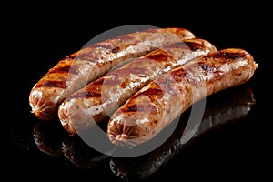Grilled sausages with grill marks on a black background