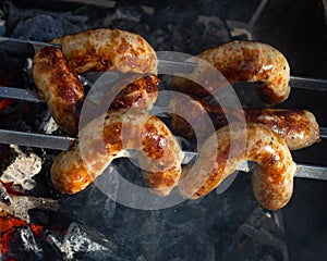 Grilled sausages on grill with smoke