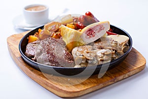 Grilled sausages with potatoes, mushrooms and roasted chicken on a grill pan