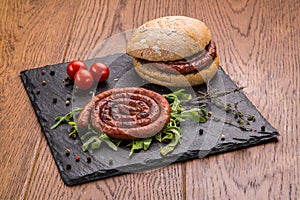 Grilled sausages ring burger with green and cherry tomatoes