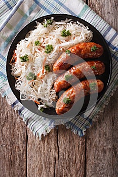 Grilled sausages and sauerkraut on the table. vertical top view