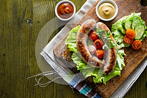 Grilled sausages served on wood board