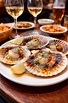 Grilled Scallops Served In Shells With White Wine In Cozy Restaurant Setting
