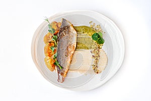 Grilled sea bass fillet with with cauliflower, sauce and pistachio.