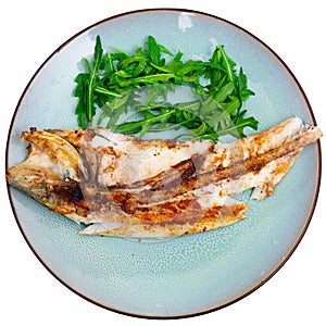 Grilled sea bass fish served with arugula