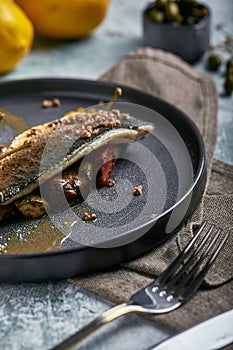 Grilled seabass with eggplant and lime. Horizontal top view, top shot. Copy space, gray concrete marble background, soft