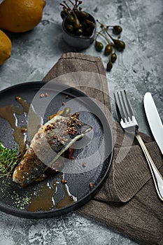 Grilled seabass with eggplant and lime. Horizontal top view, top shot. Copy space, gray concrete marble background, soft