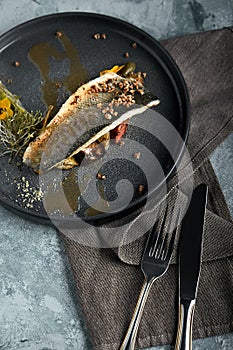 Grilled seabass with eggplant and lime. Horizontal top view, top shot. Copy space, gray concrete marble background, soft