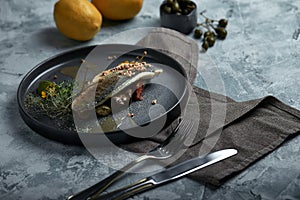 Grilled seabass with eggplant and lime. Horizontal top view, top shot. Copy space, gray concrete marble background, soft