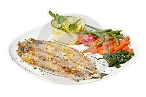 Grilled seabass fith with lemon, tomato and boiled vegetables on white background