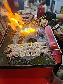 Grilled seafood skewer with flambe torch
