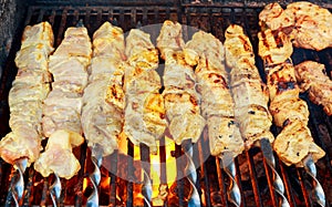 Grilled shish kebab on metal skewer. Chef hands cooking roasted meat barbecue with lots of smoke.