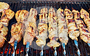 Grilled shish kebab on metal skewer. Chef hands cooking roasted meat barbecue with lots of smoke.