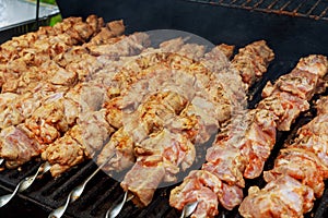 Grilled shish kebab on metal skewer. Chef hands cooking roasted meat barbecue with lots of smoke.