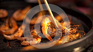 Grilled shrimp on hot steam smoke water from hot pan for cooking in party