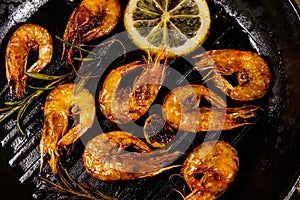 Grilled shrimp with spices, rosemary and lemon on grill frying pan