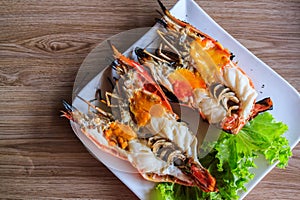Grilled shrimp with tallow on wood background