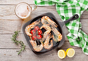 Grilled shrimps on frying pan and beer